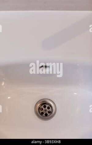 Dieses moderne Waschbecken verfügt über einen schlanken Abfluss aus Edelstahl, der Stil und Funktionalität vereint Stockfoto