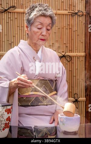 19. Juni 2017: Eine traditionell gekleidete japanische Frau mischt grünen Tee, während sie die Omotesenkei-Teezeremonie in Huntington Beach, CA, vorführt. Diese raffinierte japanische Teezeremonie soll Respekt durch Anmut und Etikette demonstrieren. Beachten Sie die Wand des Bambus-Teehauses. (Kreditbild: © Spencer Grant/ZUMA Press Wire) Stockfoto