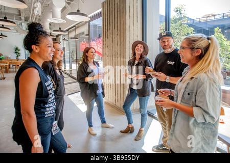 10. August 2017, Costa Mesa, Kalifornien: Junge Erwachsene Mitarbeiter des Firmensitzes der Vans Shoe Company in Costa Mesa, KALIFORNIEN, treffen sich bei kostenlosen Snacks. Beachten Sie den zentralen Innenhof im Hintergrund. (Kreditbild: © Spencer Grant/ZUMA Press Wire) Stockfoto