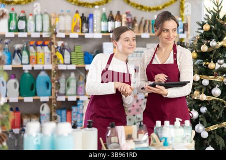 Frau Verkäuferin mit Teenager-Tochter, mit Tablet Inventar in Haushalt Chemieladen Stockfoto