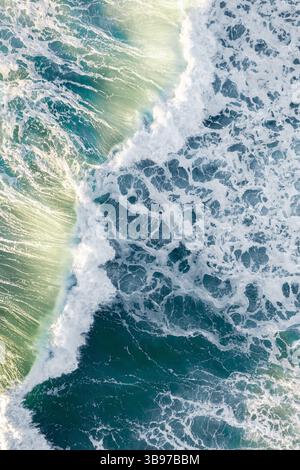 Aus der Vogelperspektive stürzende Meereswellen in der Nähe eines Strandes in Sydney, Australien, mit tiefem Türkiston und weißem Meeresschaum Stockfoto