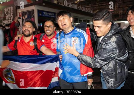 27. November 2022, Tokio, Japan: Costa-ricanische Touristen freuen sich, als ein japanischer Fußballfan beim Shibuya Scramble in Tokio schmeckt, nachdem Costa Rica Japan in einem Gruppenspiel der Katar-Weltmeisterschaft 2022 mit 1:0 besiegt hatte. Costa Rica und Japan sind jetzt auf Punkte gesetzt, aber Japan liegt vor dem Tor Differential und wetteift um einen Platz, um eine harte Gruppe E zu überleben und in die Achtelfinale aufzusteigen... Fußball, Fußball, FIFA-Weltmeisterschaft, japanische Fußballnationalmannschaft, Samurai Blue, Tokio. (Bild: © Taidgh Barron/ZUMA Press Wire) Stockfoto