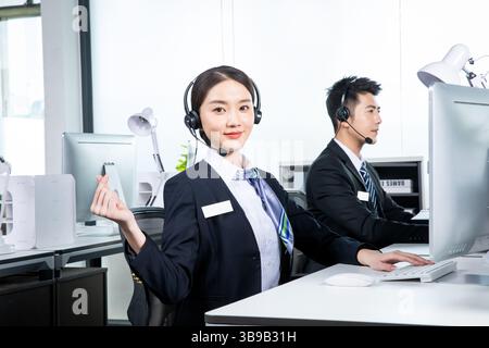 Junge Männer und Frauen, die aktiv im Callcenter arbeiten Stockfoto
