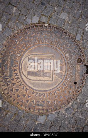 Iwano-Frankiwsk, Ukraine - 29. April 2025: Ein detailliertes Einschubfach der Stadt Iwano-Frankiwsk mit Text und ornamentalen Designs auf Kopfsteinpflasterboden. Stockfoto