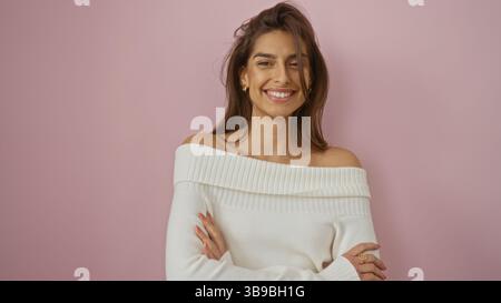 Frau lächelt selbstbewusst über einem rosafarbenen Hintergrund, strahlt Schönheit und Eleganz aus, ihre hispanische Ethnizität wird durch brünette Haare und eine isolierte se ergänzt Stockfoto