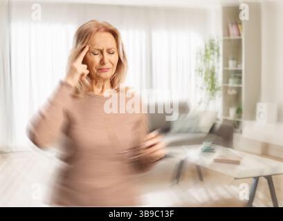 Frau mit Kopfschmerzen und Schwindelgefühl zu Hause Stockfoto