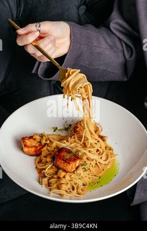 Spaghetti mit rotem Fisch und Sauce in einem Restaurant Stockfoto