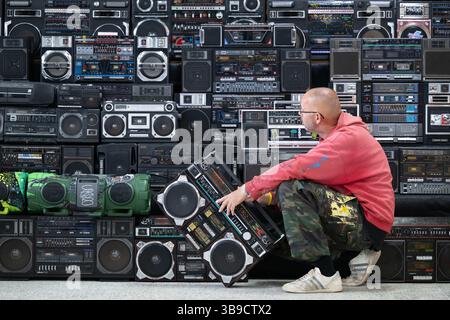 Dresden, Deutschland. Mai 2025. Sebastian Girbig kontrolliert seine Sammlung von rund 60 tragbaren Musiksystemen, umgangssprachlich auch Boomboxen genannt, in der ehemaligen Robotron-Kantine. Die Sammlung ist Teil des erstmals stattfindenden Hip-Hop-Festivals ALL4/1, das bis zum 11. Mai 2025 die facettenreiche Hip-Hop-Kultur in Dresden präsentieren soll. Quelle: Sebastian Kahnert/dpa/Alamy Live News Stockfoto