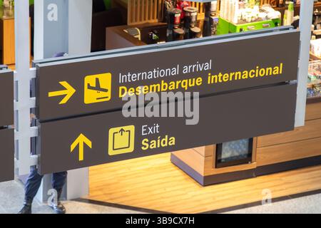 Informationstafel an einem Flughafen mit internationalen Ankunfts- und Abflügen. Stockfoto