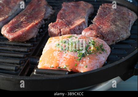Genießen Sie den Geschmack von köstlichem gegrilltem Steak und perfekt gekochtem Lachs auf einem Grill Stockfoto