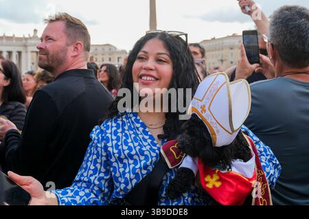 Eine Frau posiert mit ihrem Hund Romeo, gekleidet als Papst, am zweiten Tag des Konklaves im Vatikan am 8. Mai 2025 auf dem Petersplatz Stockfoto