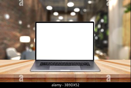 Laptop-Computer mit leerem Bildschirm auf Holztisch mit verschwommenem Café-Restaurant mit abstraktem Bokeh-Licht-defokussiertem Hintergrund. Stockfoto