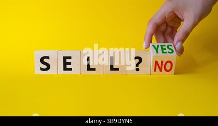 Symbol „Ja“ oder „Nein“ verkaufen. Die Hand des Geschäftsmannes dreht Würfel und ändert die Wörter „Verkaufen Nein“ in „Verkaufen Ja“. Schöner gelber Hintergrund. Geschäfts- und Verkaufskonzept. Cop Stockfoto