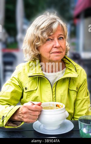 Eine schwedische blonde Frau, die eine Suppe genießt Stockfoto