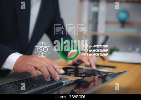 Qualitätssicherung, Geschäftsmann mit Laptop mit ISO-Zertifizierung, Dokumentenzulassung und Compliance-Management-Konzept für internationale Standards Stockfoto
