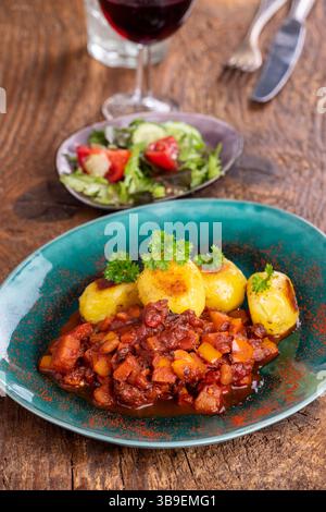 Gulasch mit Kartoffeln auf Holz Stockfoto