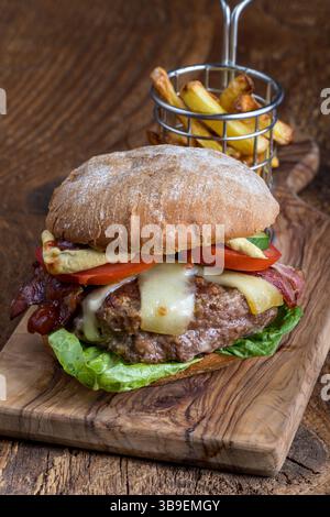 Cheeseburger mit Pommes frites auf Holz Stockfoto