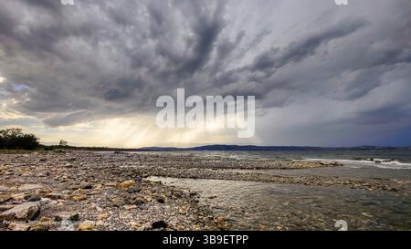 Die Sonne bricht durch dunkle Wolken Stockfoto