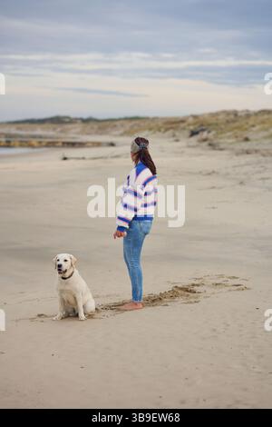 Aktive Frau mit Hund am Strand Stockfoto