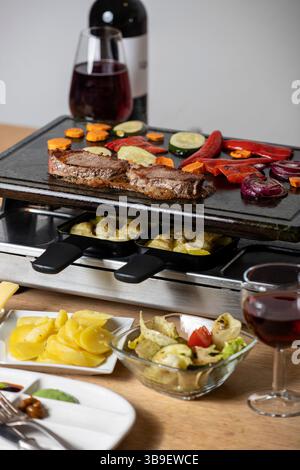 Schweizer Raclette mit Fleisch und Gemüse Stockfoto