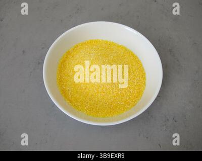 Polenta Maismehl in einer flachen Schüssel und Maiskörner Stockfoto