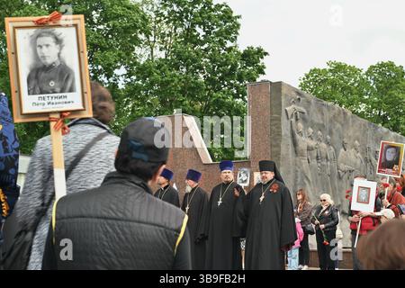Lipetsk, Russland. Mai 2025. Priester unter einer Menschenmenge mit Porträtbildern ihrer Vorfahren, die in der Nähe der Gedenkstätte für die Soldaten des Großen Vaterländischen Krieges während der Veranstaltung kämpften. Massenveranstaltungen und die Militärparade am 9. Mai wurden abgesagt, aber kleine Festveranstaltungen fanden spontan in den Parks und Plätzen der Stadt statt. Quelle: SOPA Images Limited/Alamy Live News Stockfoto