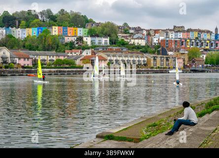 Beobachten Sie die Jollen im schwimmenden Hafen von Bristol mit den farbenfrohen Häusern von Clifton Wood in der Diastance - Bristol UK Stockfoto
