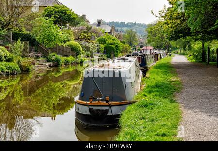 Schmalboote, die entlang des Kesselwegs des Kennet- und Avon-Kanals in Bath Somerset, Großbritannien, vor eleganten Kanalhäusern und Gärten liegen Stockfoto