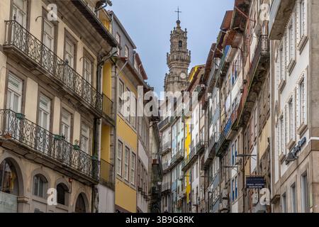 Hohe Canyons von Gebäuden in der Altstadt von Porto's. Farbenfrohe Fassaden. Kirchturm im Hintergrund, Portugal Stockfoto
