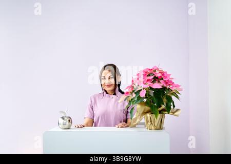 Das Personal in einem professionellen Schönheitssalon nimmt sich einen Moment Zeit, um Gäste zu begrüßen. Der Bereich hat sanfte Farben und eine dekorative Pflanze, die ein warmes, wir Stockfoto