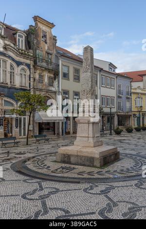 Alter Platz mit Denkmal und Mosaiksteinen in Aveiro. Alte Stadthäuser im Hintergrund, Portugal Stockfoto