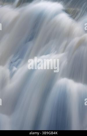 Ätherische Langzeitaufnahme von kaskadendem Wasser in Presa del Villar, Madrid, mit einer glatten, seidigen Wasserstruktur. Stockfoto