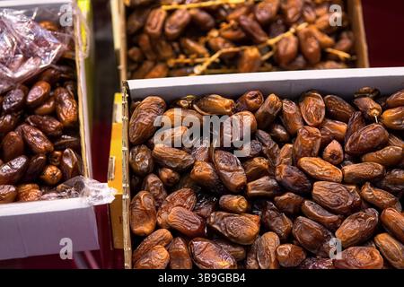Ausgewählte Trockendaten in Kartons auf dem Markt, Draufsicht. Natürliche orientalische Süßigkeiten. Stockfoto