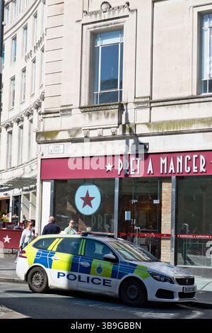 Ein Polizeiauto parkt auf einer Straße vor einer Pret A Manger. Menschen laufen in der Nähe. Das Gebäude ist aus hellem Stein in Liverpool, Großbritannien. Stockfoto