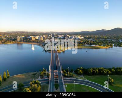Von oben bietet sich ein Blick auf Canberras Stadtbild, hervorgehoben durch gewundene Straßen und den großen Molonglo River. Die Szene wird durch ein entferntes h ergänzt Stockfoto