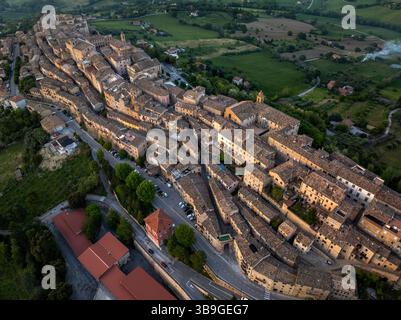 Aus der Vogelperspektive von Treia, Italien, mit seiner bemerkenswerten mittelalterlichen Architektur, eingebettet in üppige Felder. Dieses Panorama erfasst das einzigartige Layout von t Stockfoto