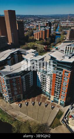 Blick aus der Vogelperspektive auf moderne Apartmenthäuser und Stadtlandschaft unter einem klaren blauen Himmel an einem sonnigen Tag, mit Kanal und Stadtlandschaft in Leeds, Großbritannien. Stockfoto