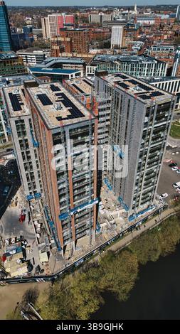 Luftaufnahme von drei im Bau befindlichen hohen Gebäuden in einem städtischen Gebiet mit Solarpaneelen, Kränen und umliegenden Stadtbildern in Leeds, Großbritannien. Stockfoto