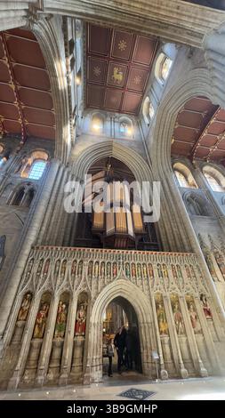 Innenansicht einer Kathedrale mit einer großen Pfeifenorgel über einem reich verzierten, bogenförmigen Eingang mit Skulpturen und einer Kassettendecke. Stockfoto