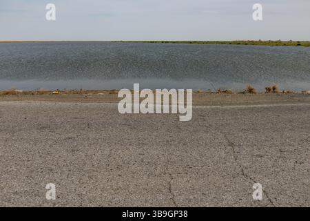 Überflutete Steppenlandschaft an Asphaltstraße nach Hochwasser in Kasachstan Stockfoto