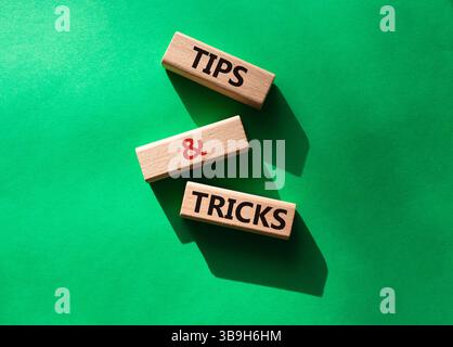 Symbol für Tipps und Tricks. Holzblöcke mit Worten Tipps und Tricks. Schöner grüner Hintergrund. Geschäftskonzept und Tipps und Tricks. Kopierbereich. Stockfoto
