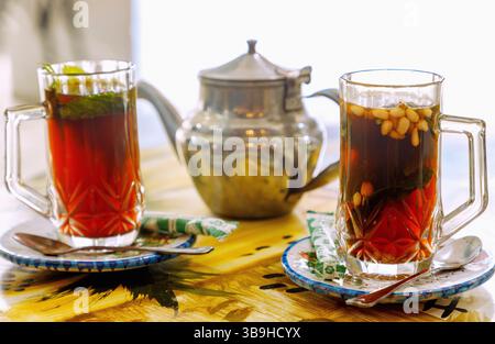 Pfefferminztee im arabischen Stil mit Pinienkernen, serviert in einer silbernen Teekanne in einem tunesischen Café im Souk in Nabeul, Tunesien Stockfoto