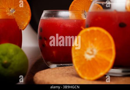 Ein lebendiger und erfrischender Sommer-Wassermelonencocktail, serviert in einem runden Glas, garniert mit frischen Orangenscheiben und gefüllt mit gekühltem roten Saft und Stockfoto