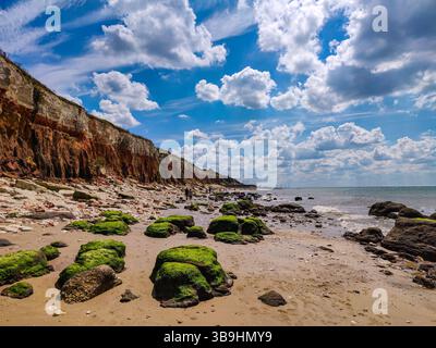 Malerischer Blick auf den Strand von Hunstanton, Norfolk, England. Sand, Meer, Wolken und grüne Felsen bedeckt mit Algen Stockfoto