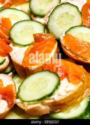 Herzhafte Köstlichkeiten von Räucherlachs und Gurke serviert auf frisch gebackenem Brot in einem herrlichen Sommeraufstrich Stockfoto