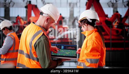 Junger Latino-Ingenieur, Der Halbleitergeräte In Der Elektroautofabrik Inspiziert. Stockfoto