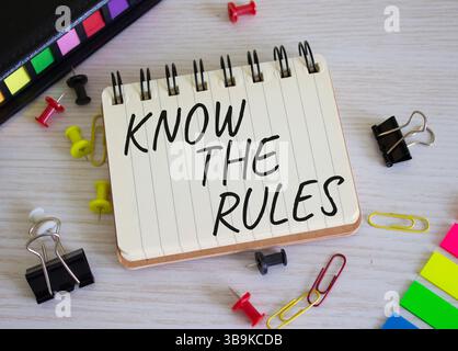 Kennen Sie das Regelsymbol. Konzeptwörter kennen die Regeln für weißes Notizbuch. Schöner Holzhintergrund. Und kennen Sie das Regelkonzept. Kopierbereich. Stockfoto
