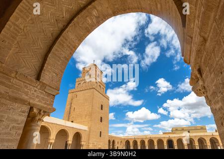 Bogenblick auf den Minarettturm der Großen Moschee von Uqba mit Wolken am blauen Himmel, Kairouan, Tunis Stockfoto