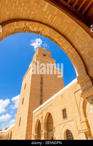 Bogenblick auf den Minarettturm der Großen Moschee von Uqba mit Wolken am blauen Himmel, Kairouan Stockfoto