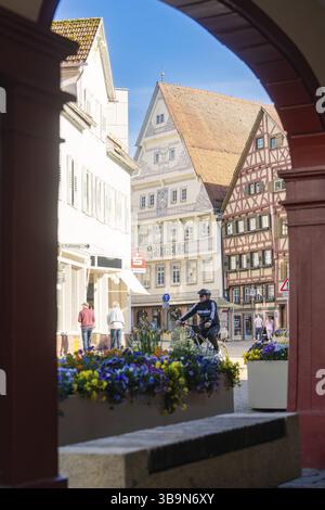 Blick durch einen Torbogen auf eine Straße mit Fachwerkhäusern und einem Radfahrer in einer sonnigen Stadt, Nagold, Schwarzwald, Deutschland, Europa Stockfoto